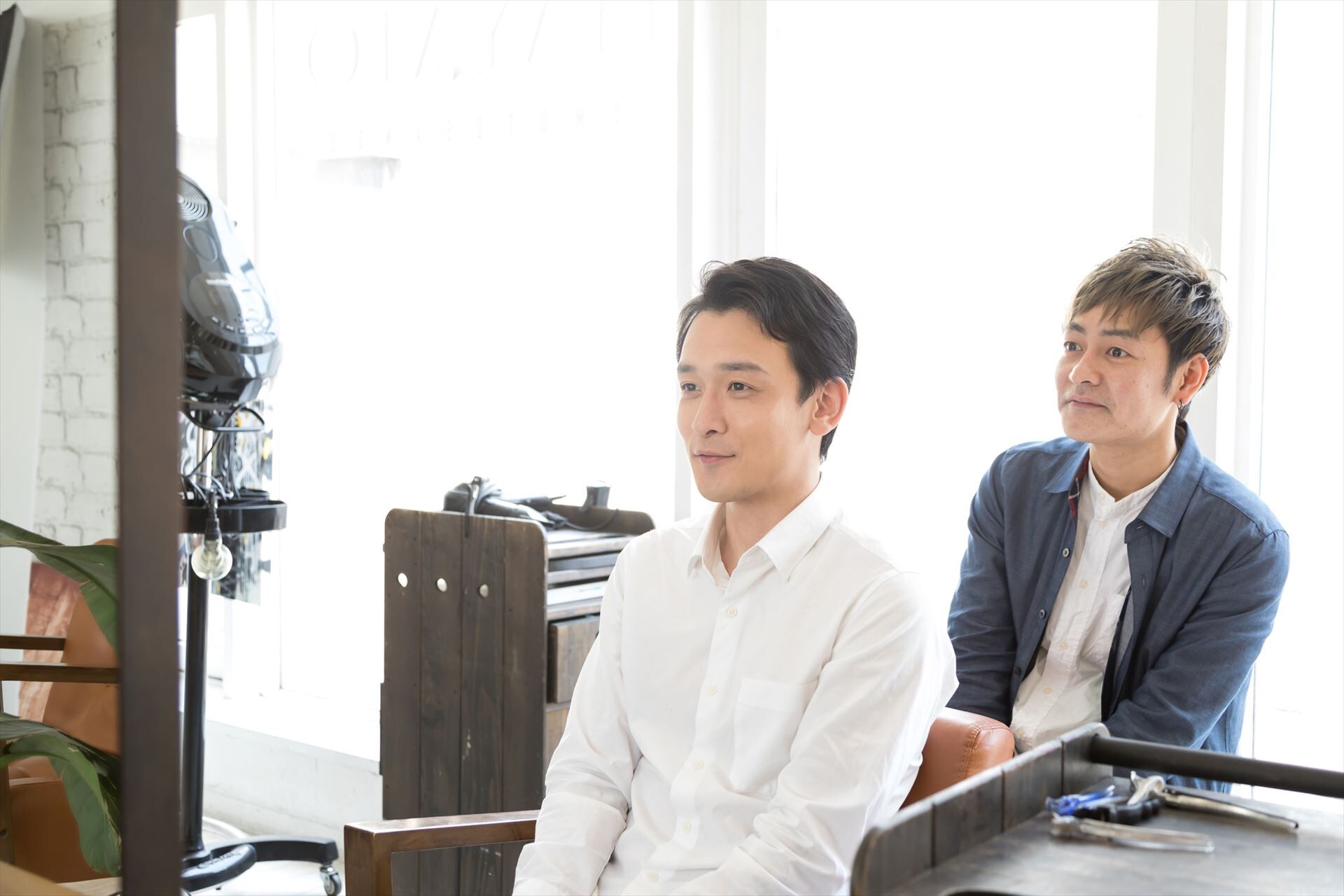 完成したヘアスタイルを確認するスタッフ